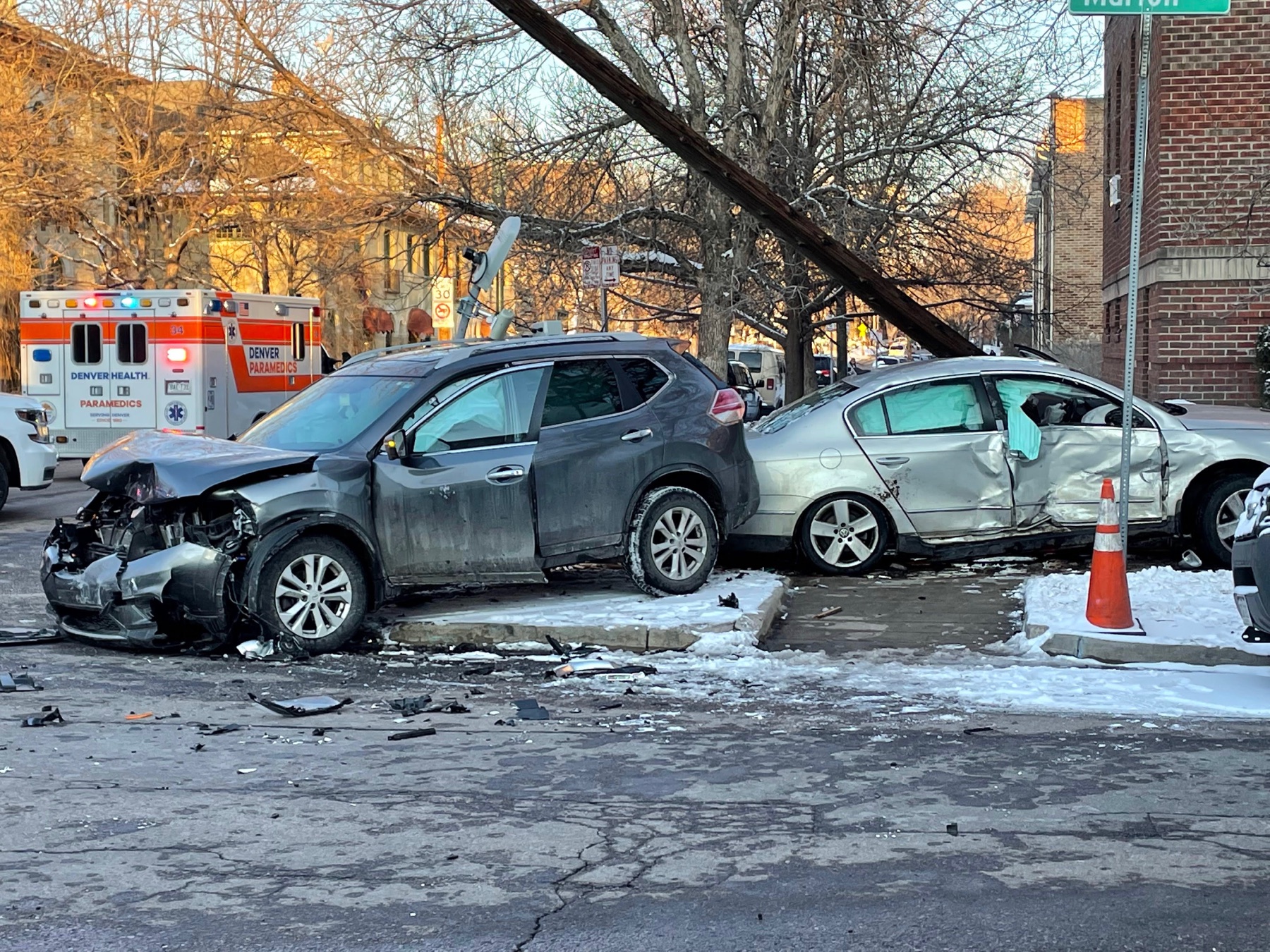 Two badly damaged vehicles at a snowy East Avenue intersection as paramedics respond